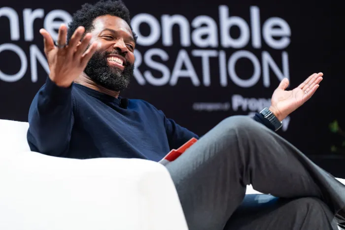 Baratunde Thurston laughing mid-conversation at A Day of Unreasonable Conversation
